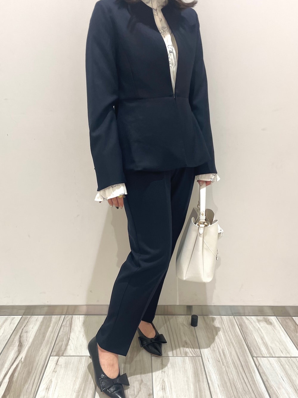 ブルー系のスラックス、ブルー系のノーカラージャケット、ホワイト系のシャツ/ブラウスを着用したレディースの冬コーディネートの3枚目の写真