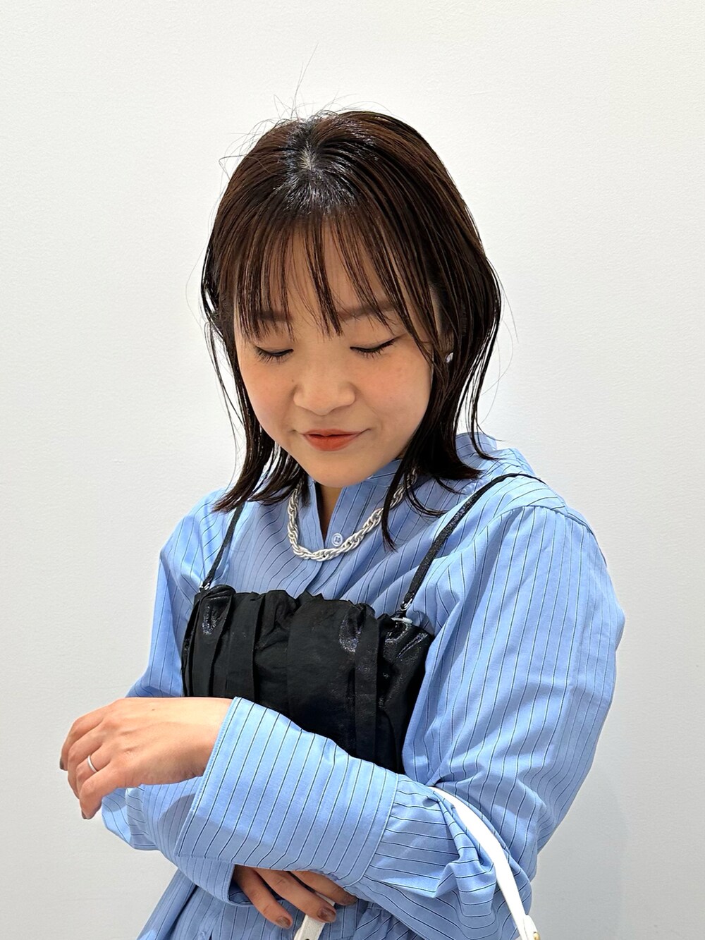 ブラック系のキャミソール、ブルー系のシャツ/ブラウス、ブラック系のスカートを着用したレディースの秋コーディネートの2枚目の写真