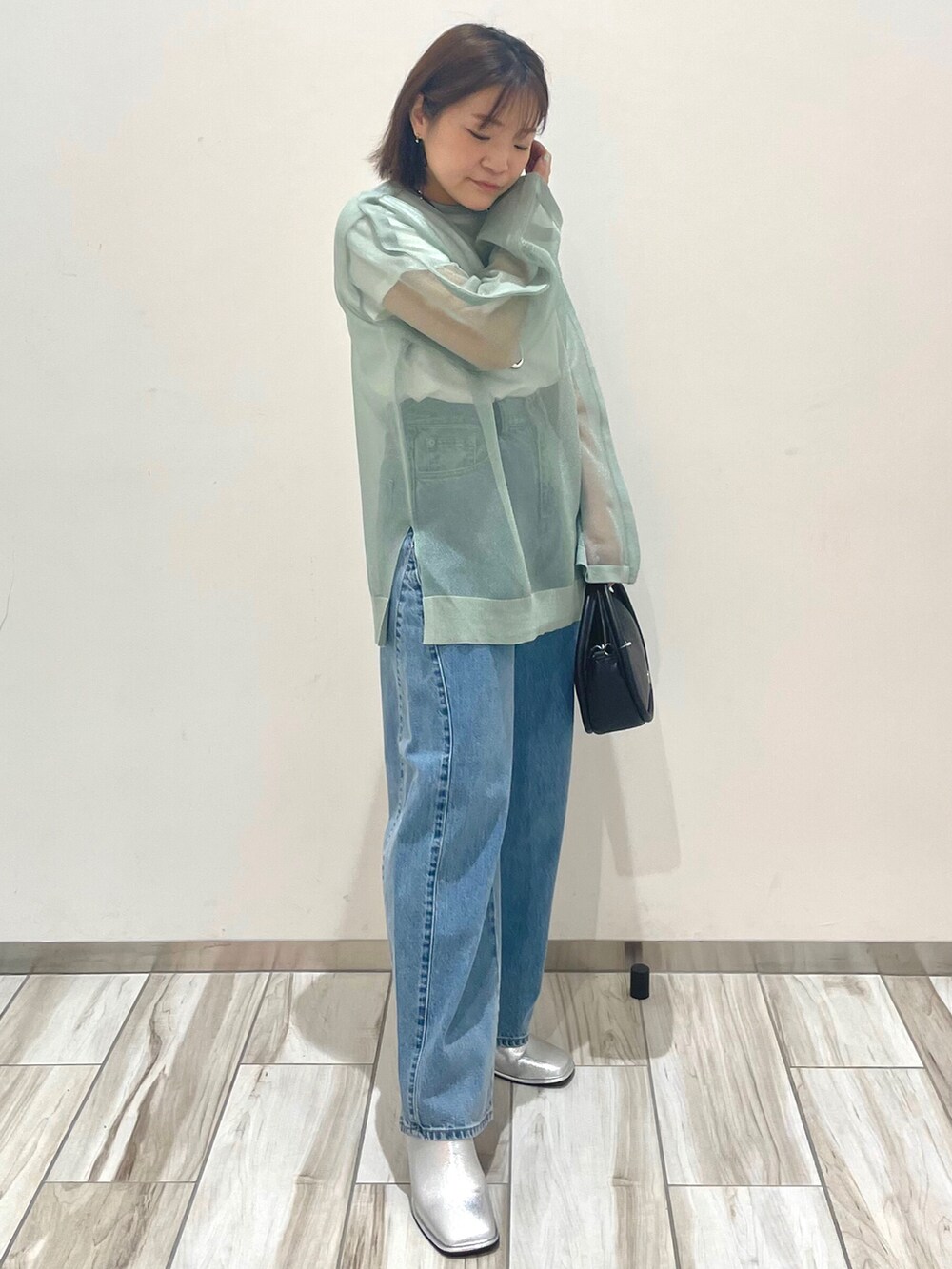 グリーン系のシャツ/ブラウス、ホワイト系のTシャツ/カットソー、ブルー系のデニムパンツを着用したレディースの春コーディネートの2枚目の写真