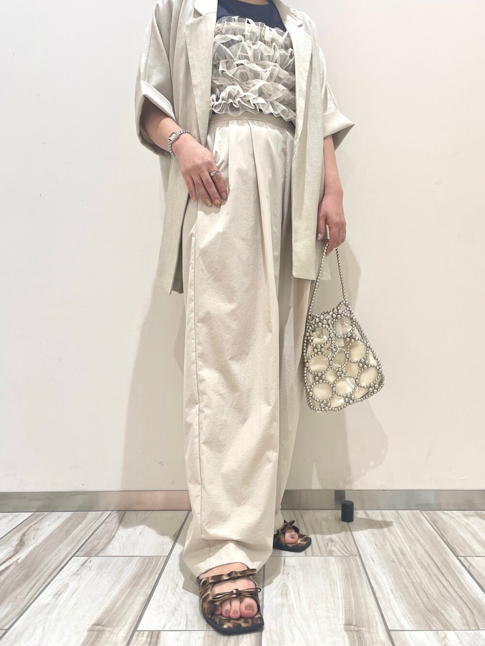 ホワイト系のテーラードジャケット、ベージュ系のその他パンツ、シルバー系のハンドバッグを着用したレディースの春コーディネートの3枚目の写真