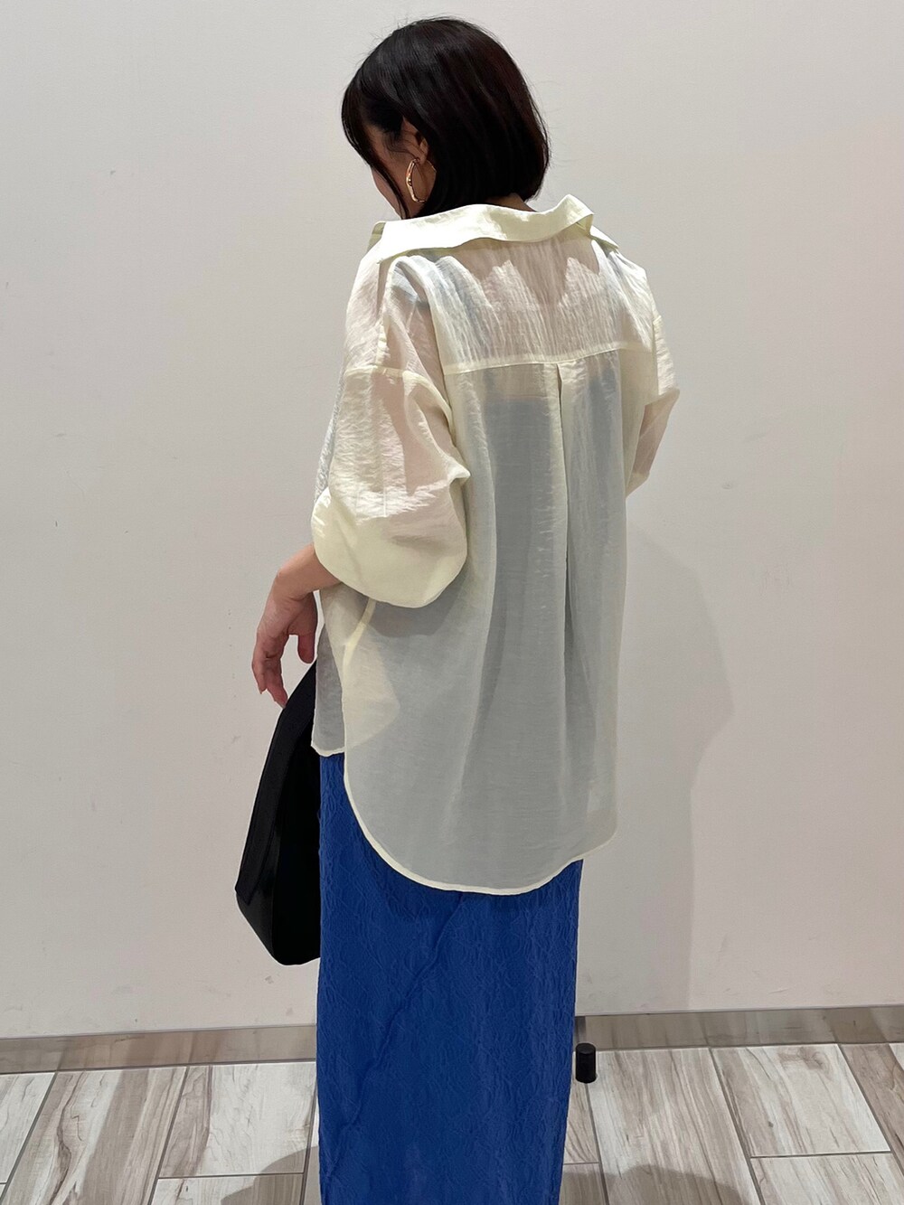 ブルー系のワンピース、ホワイト系のシャツ/ブラウスを着用したレディースの春コーディネートの3枚目の写真