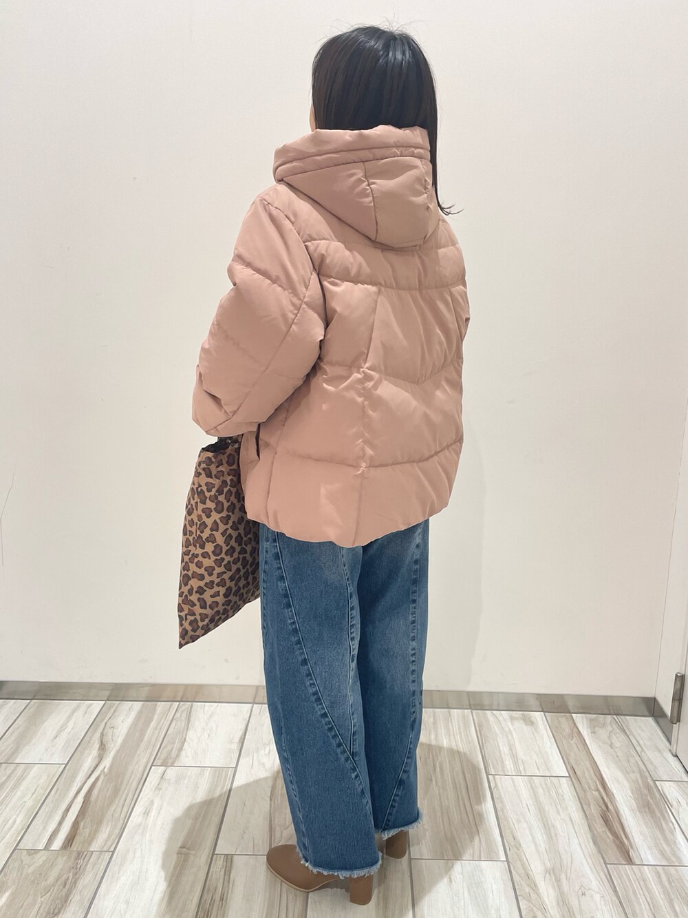 ピンク系のダウンジャケット/コート、ブルー系のデニムパンツ、ブラウン系のトートバッグを着用したレディースの冬コーディネートの5枚目の写真