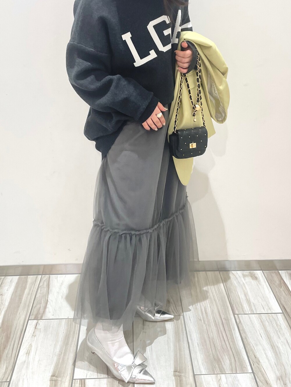 グレー系のスカート、ブラック系のニット/セーターを着用したレディースの冬コーディネートの3枚目の写真