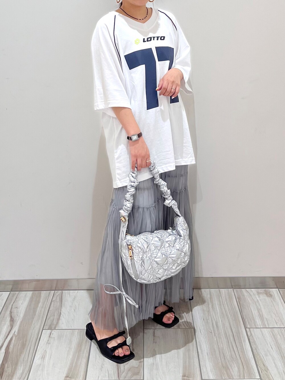 グレー系のスカート、シルバー系のショルダーバッグを着用したレディースの夏コーディネートの2枚目の写真