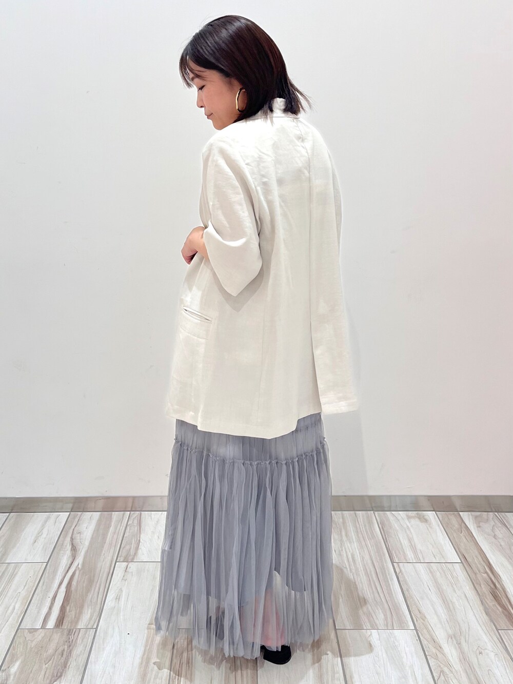 ホワイト系のハンドバッグ、ホワイト系のテーラードジャケット、ホワイト系のニット/セーターを着用したレディースの夏コーディネートの5枚目の写真