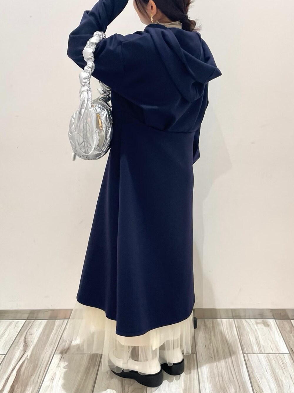 ブルー系のワンピース、ホワイト系のスカート、シルバー系のショルダーバッグを着用したレディースの冬コーディネートの4枚目の写真