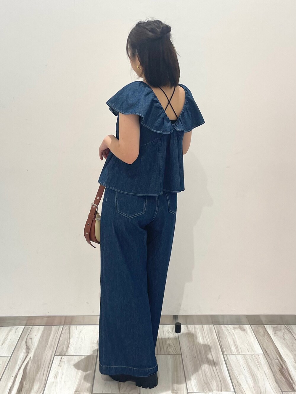 ブルー系のシャツ/ブラウス、ブルー系のデニムパンツ、ブラウン系のショルダーバッグを着用したレディースの春コーディネートの3枚目の写真