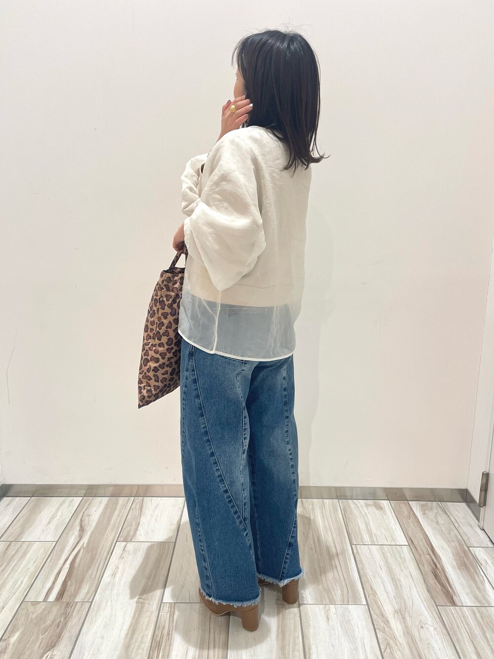 ベージュ系のスウェット、ブルー系のデニムパンツを着用したレディースの冬コーディネートの4枚目の写真