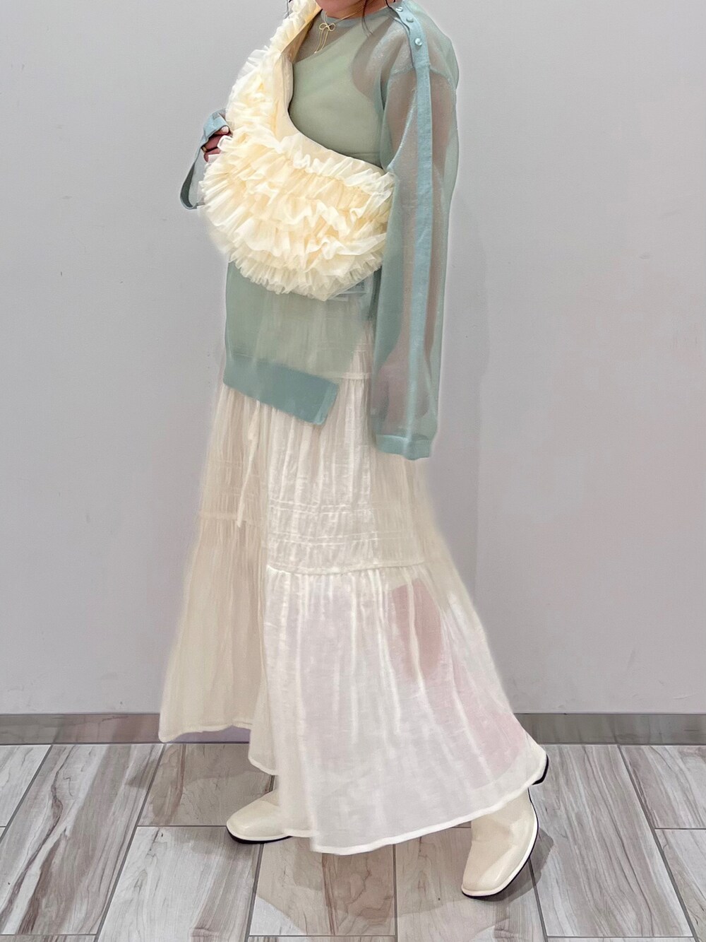 ホワイト系のショルダーバッグ、グリーン系のシャツ/ブラウス、ホワイト系のスカートを着用したレディースの春コーディネートの2枚目の写真