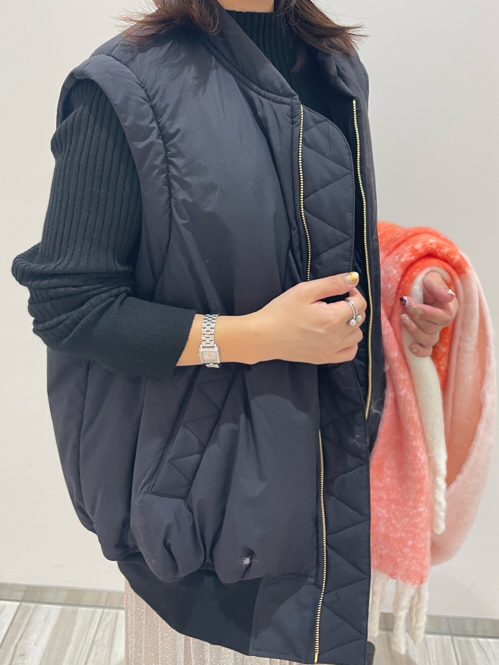 ブラック系のニット/セーター、ブラック系のブルゾン、シルバー系のスカートを着用したレディースの秋コーディネートの2枚目の写真