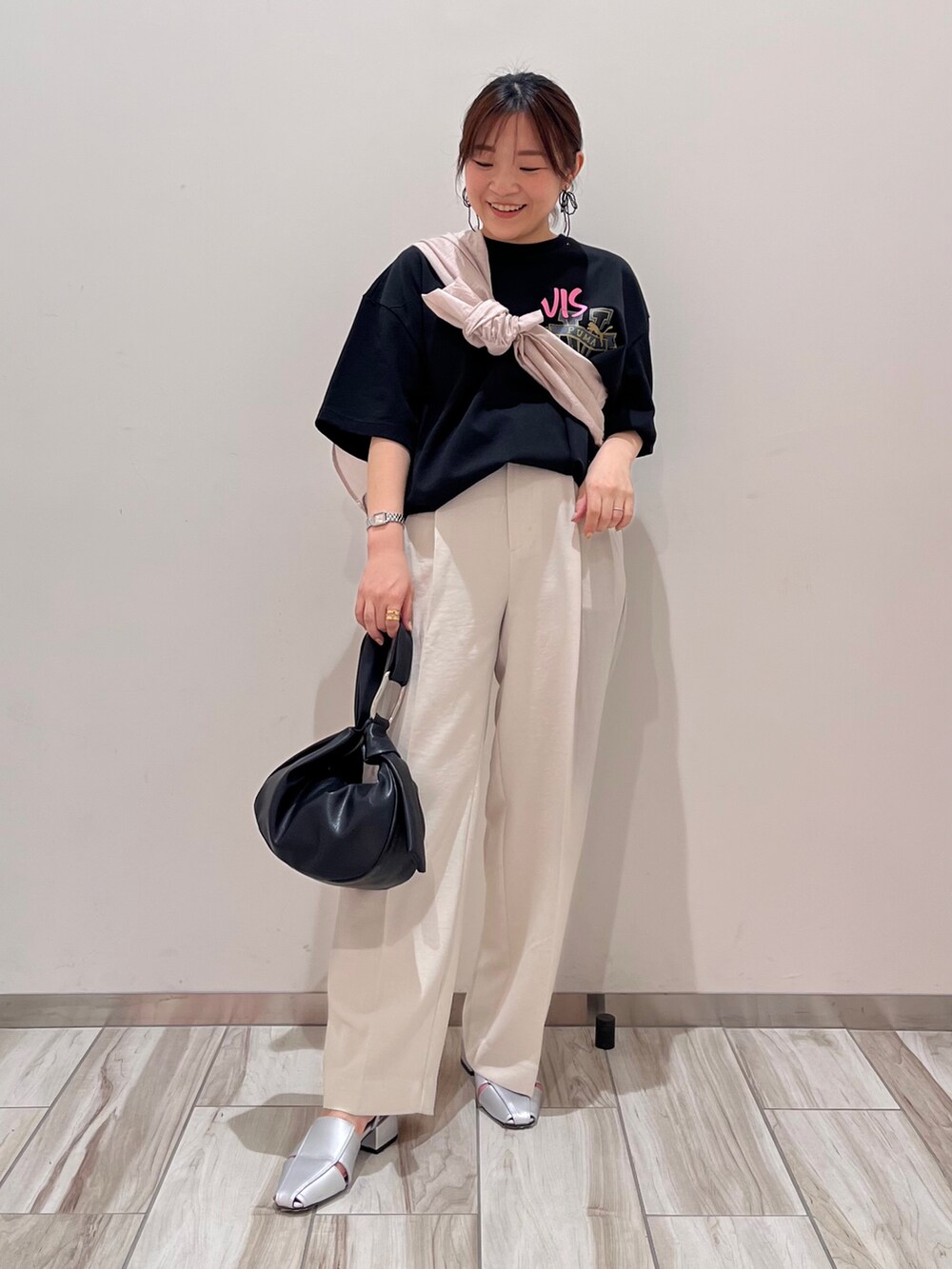 ブラック系のTシャツ/カットソー、ピンク系のシャツ/ブラウス、ホワイト系のスラックスを着用したレディースの春コーディネートの2枚目の写真