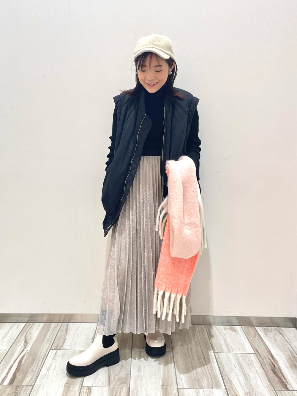 ブラック系のニット/セーター、ブラック系のブルゾン、シルバー系のスカートを着用したレディースの秋コーディネートの4枚目の写真