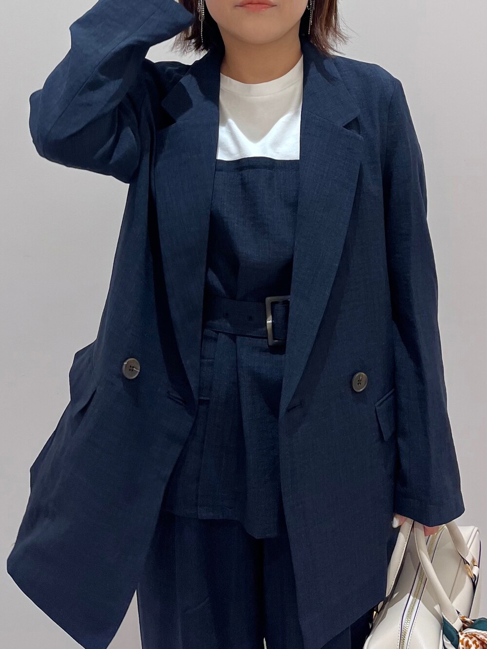 ホワイト系のボストンバッグ、ブルー系のTシャツ/カットソー、ブルー系のスラックスを着用したレディースの春コーディネートの3枚目の写真