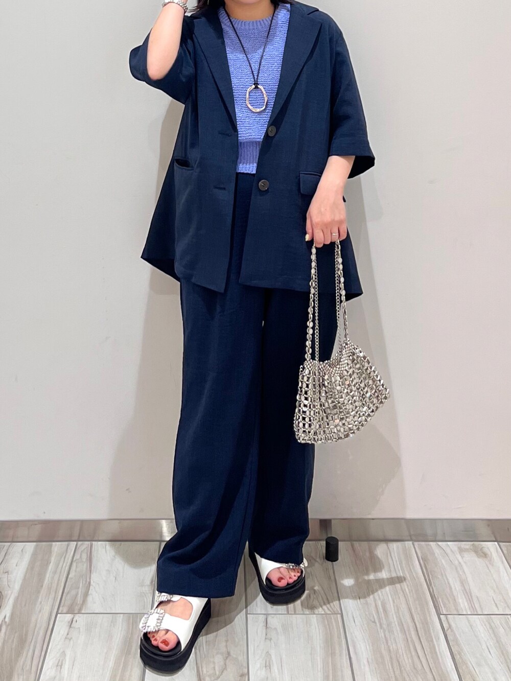 ブルー系のテーラードジャケット、ブルー系のスラックス、ブルー系のニット/セーターを着用したレディースの春コーディネートの2枚目の写真