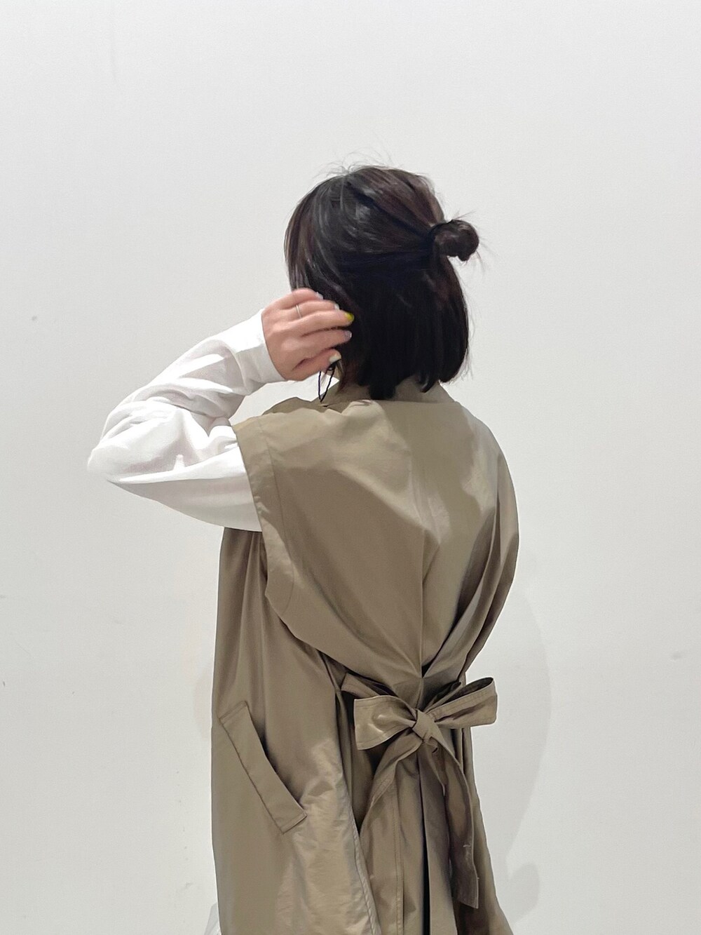 グリーン系のトレンチコート、グリーン系のカーゴパンツ、シルバー系のハンドバッグを着用したレディースの春コーディネートの2枚目の写真