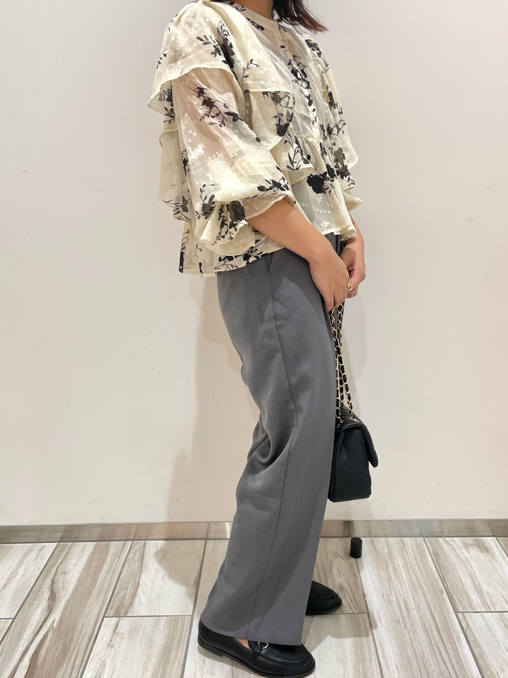 グレー系のスラックス、ホワイト系のシャツ/ブラウス、ブラック系のローファーを着用したレディースの秋コーディネートの2枚目の写真