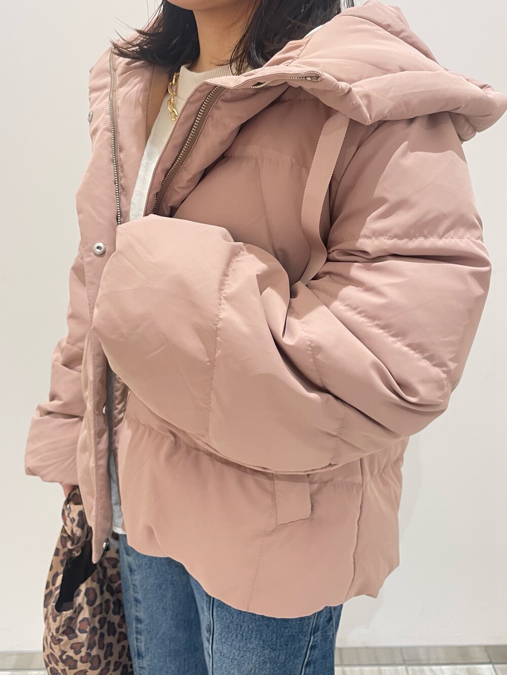 ピンク系のダウンジャケット/コート、ブルー系のデニムパンツ、ブラウン系のトートバッグを着用したレディースの冬コーディネートの3枚目の写真