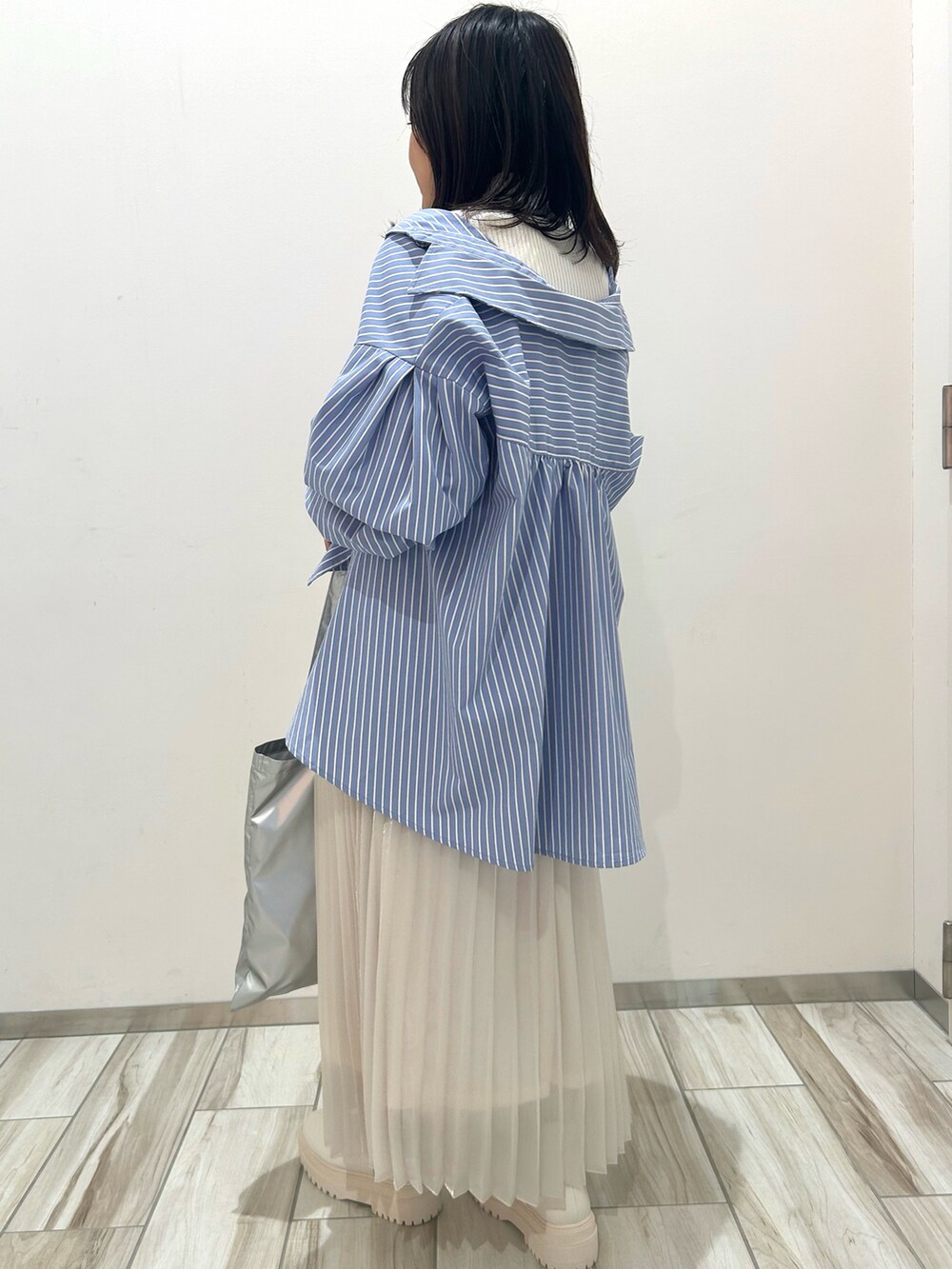 ホワイト系のブーツ、シルバー系のトートバッグ、ホワイト系のスカートを着用したレディースの冬コーディネートの4枚目の写真