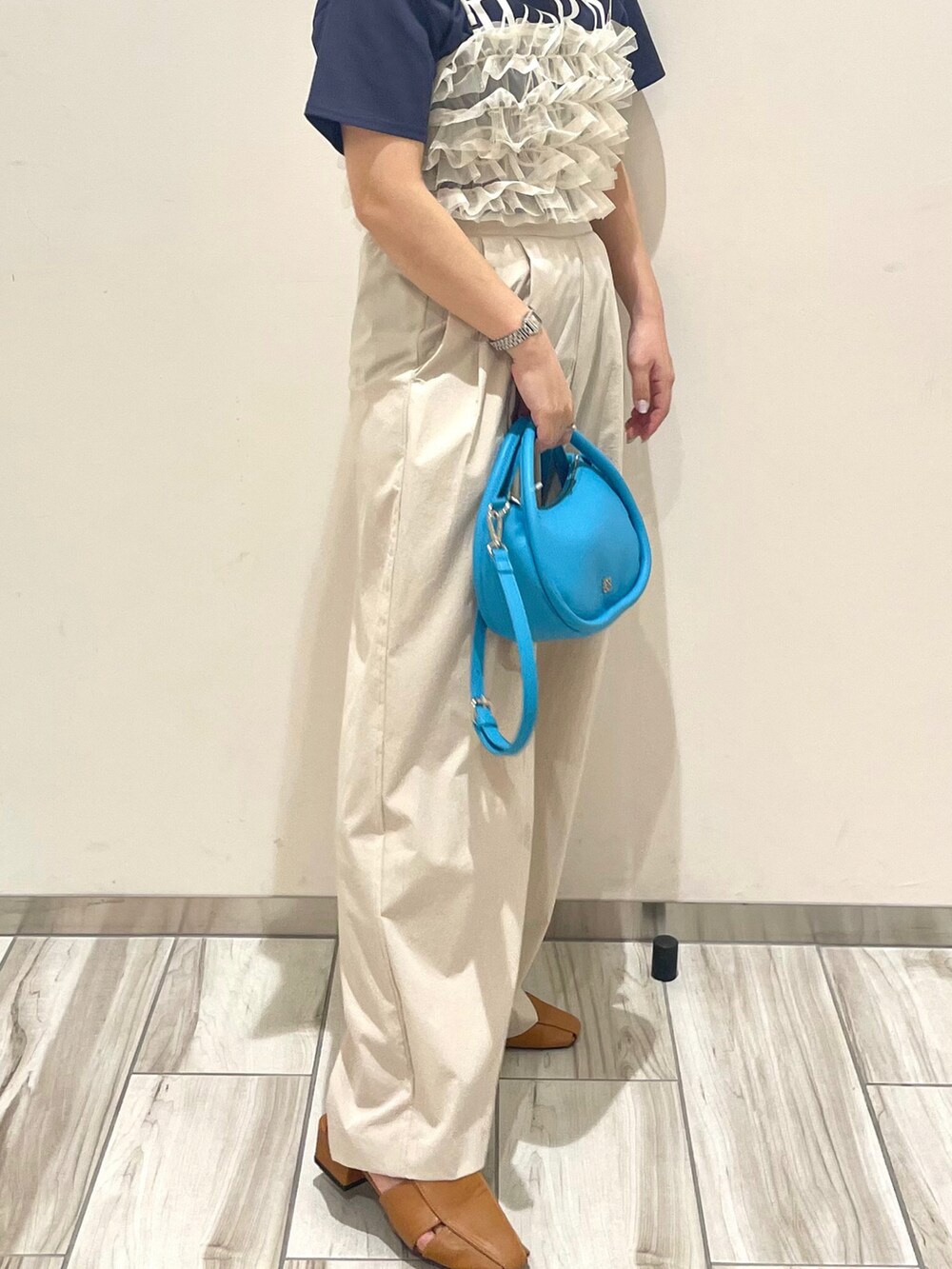 ホワイト系のキャミソール、ブルー系のTシャツ/カットソー、ベージュ系のその他パンツを着用したレディースの春コーディネートの3枚目の写真
