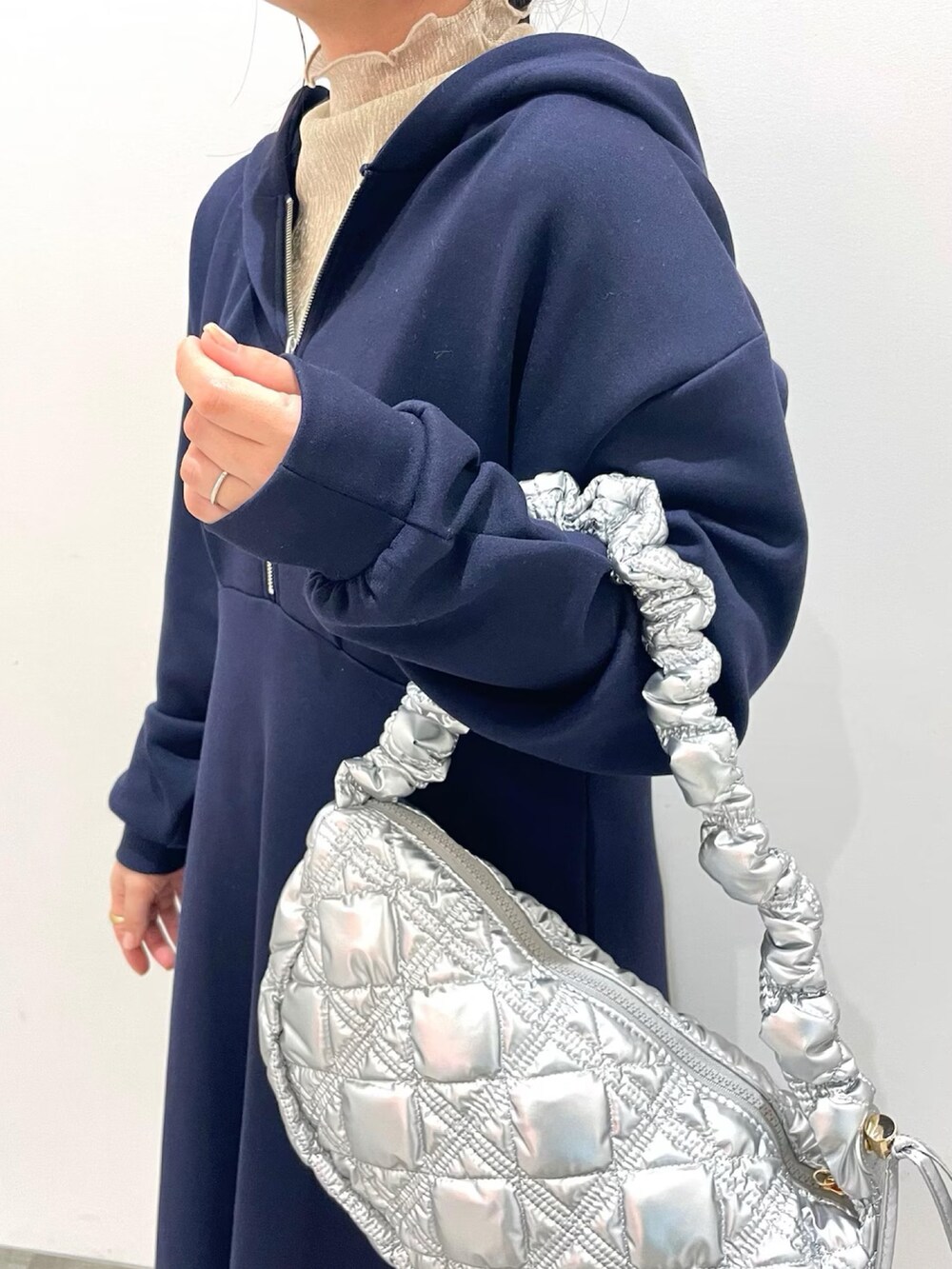 ブルー系のワンピース、ホワイト系のスカート、シルバー系のショルダーバッグを着用したレディースの冬コーディネートの2枚目の写真