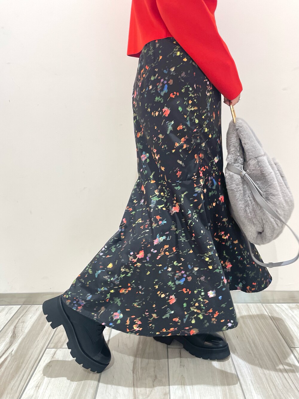 レッド系のカーディガン/ボレロ、ブラック系のスカート、ブラック系のブーツを着用したレディースの秋コーディネートの5枚目の写真