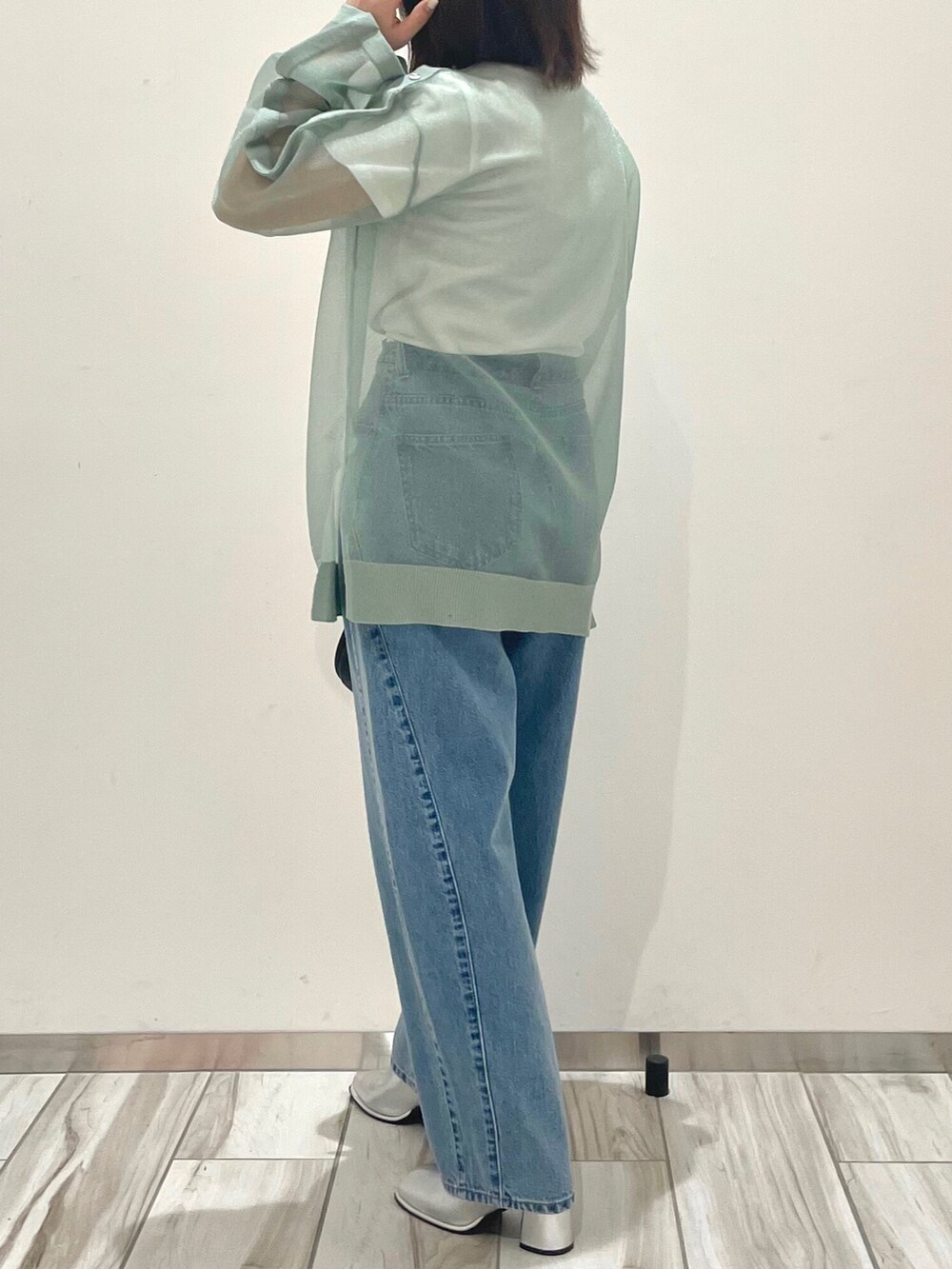 グリーン系のシャツ/ブラウス、ホワイト系のTシャツ/カットソー、ブルー系のデニムパンツを着用したレディースの春コーディネートの4枚目の写真