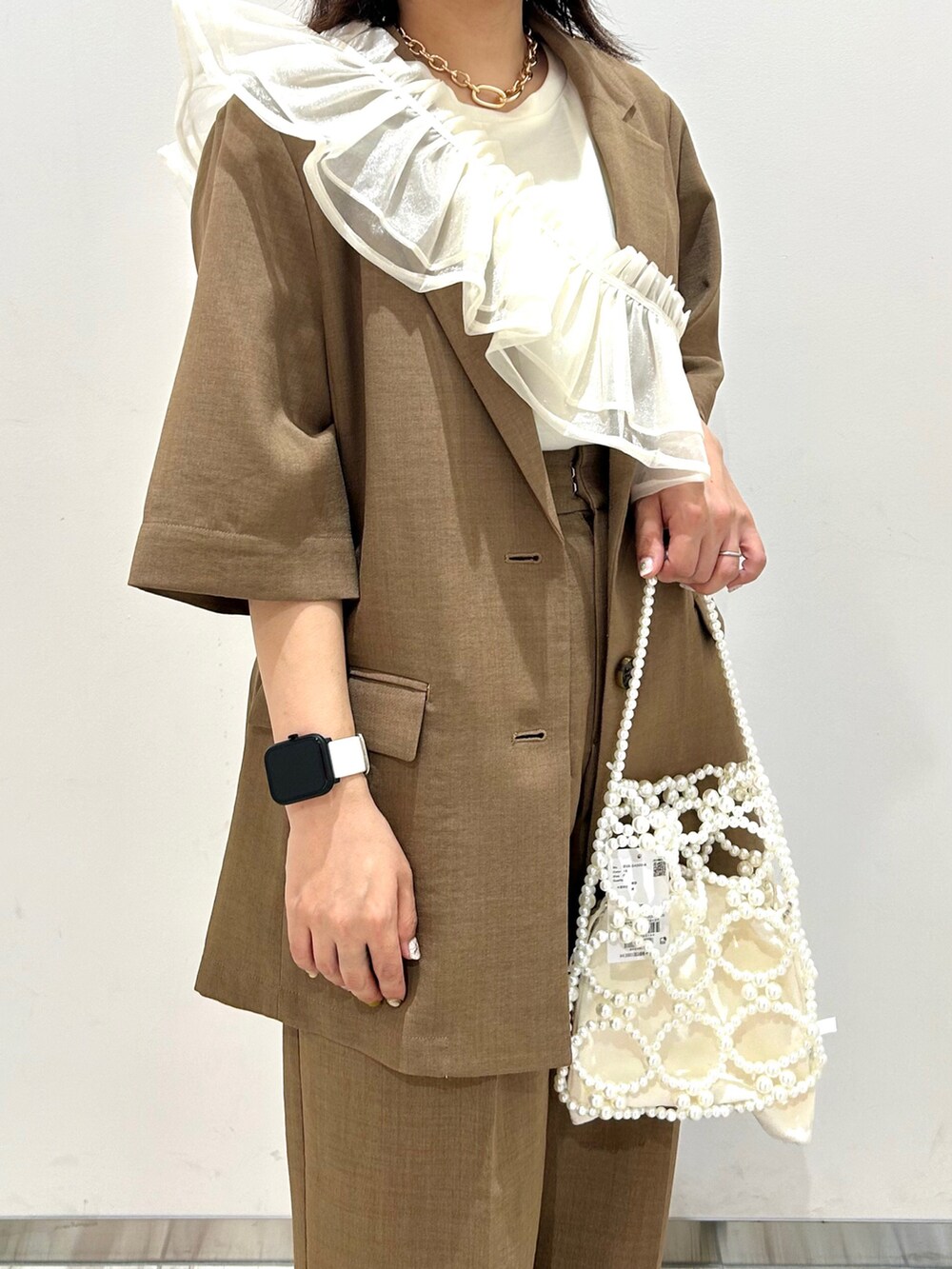 ホワイト系のTシャツ/カットソー、ブラウン系のテーラードジャケット、ブラウン系のスラックスを着用したレディースの夏コーディネートの2枚目の写真