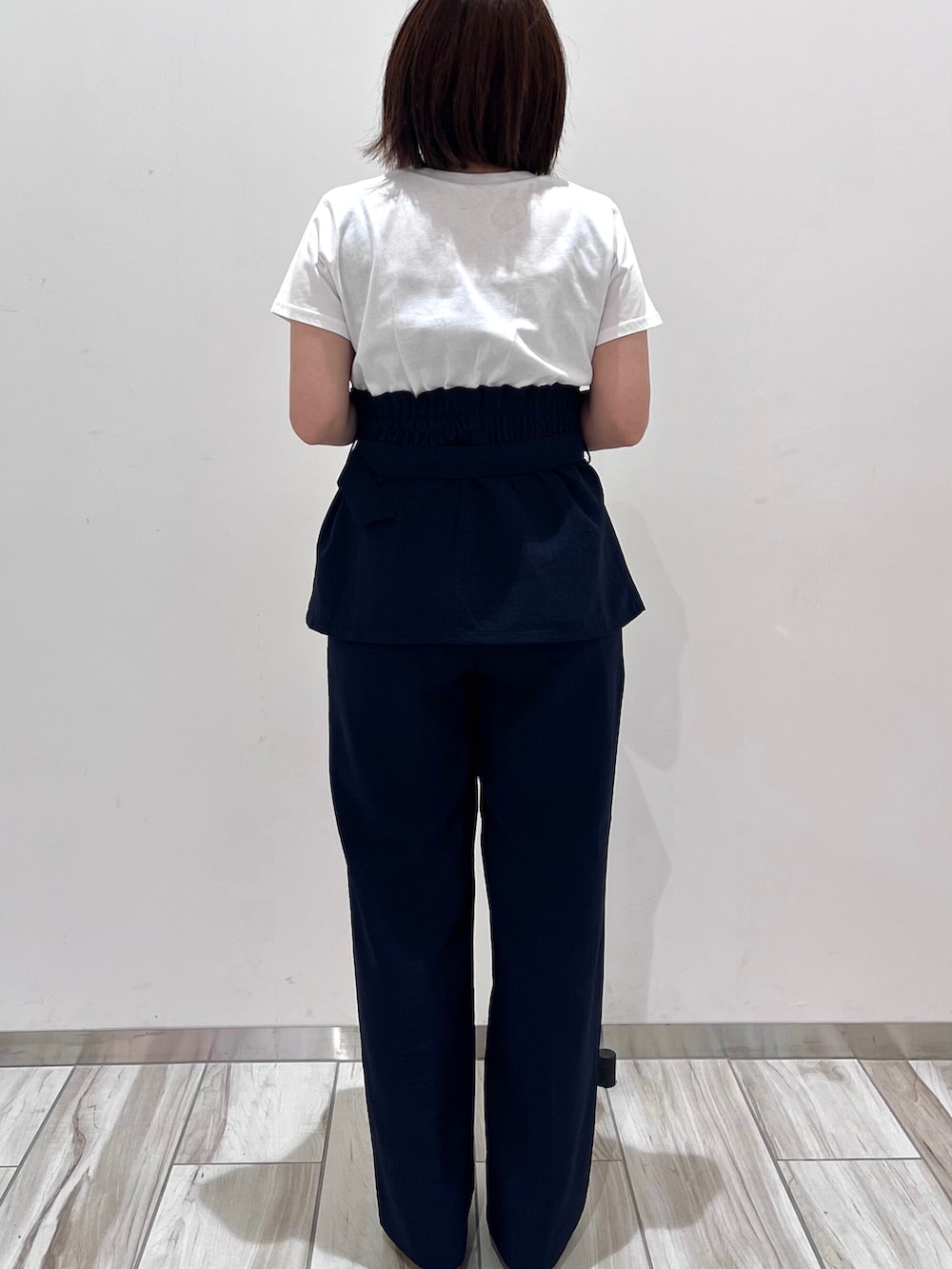 ブルー系のTシャツ/カットソー、ブルー系のスラックス、ホワイト系のボストンバッグを着用したレディースの春コーディネートの4枚目の写真