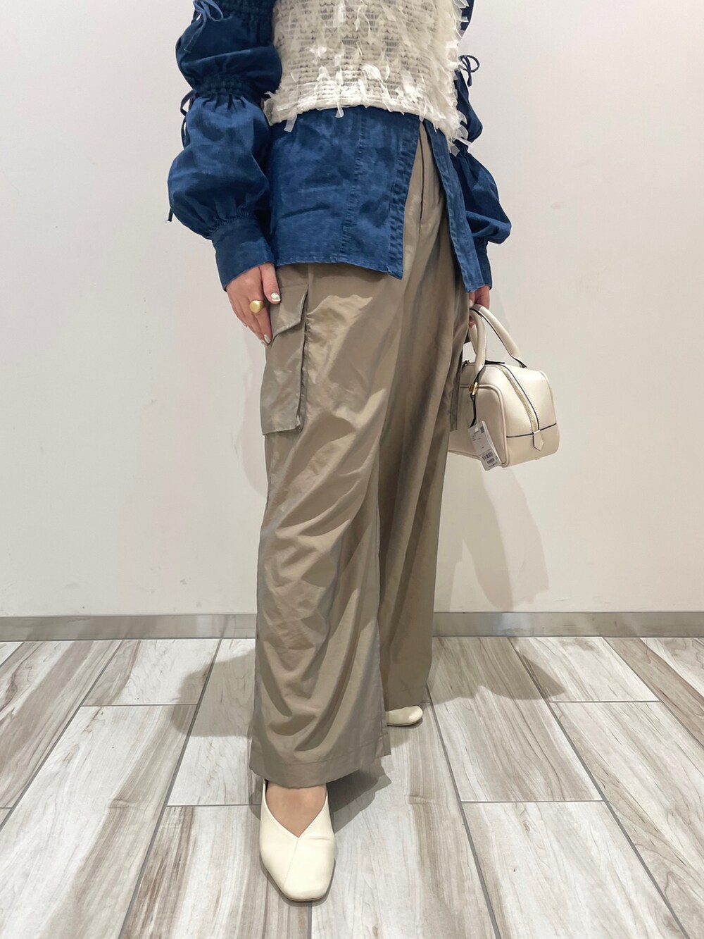 ホワイト系のボストンバッグ、グリーン系のカーゴパンツ、ホワイト系のキャミソールを着用したレディースの春コーディネートの3枚目の写真