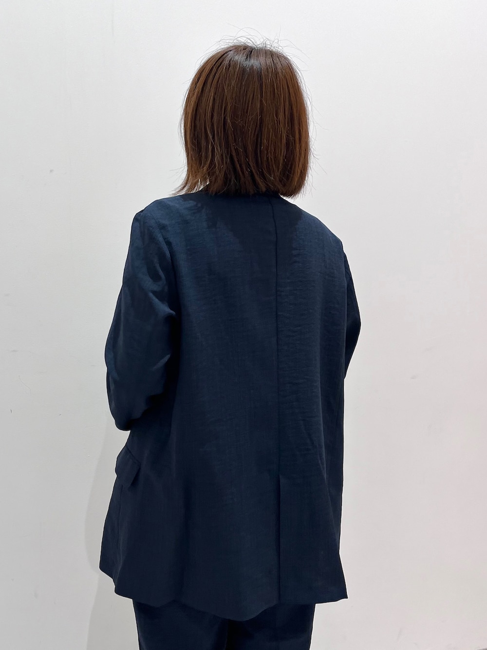 ホワイト系のボストンバッグ、ブルー系のTシャツ/カットソー、ブルー系のスラックスを着用したレディースの春コーディネートの4枚目の写真