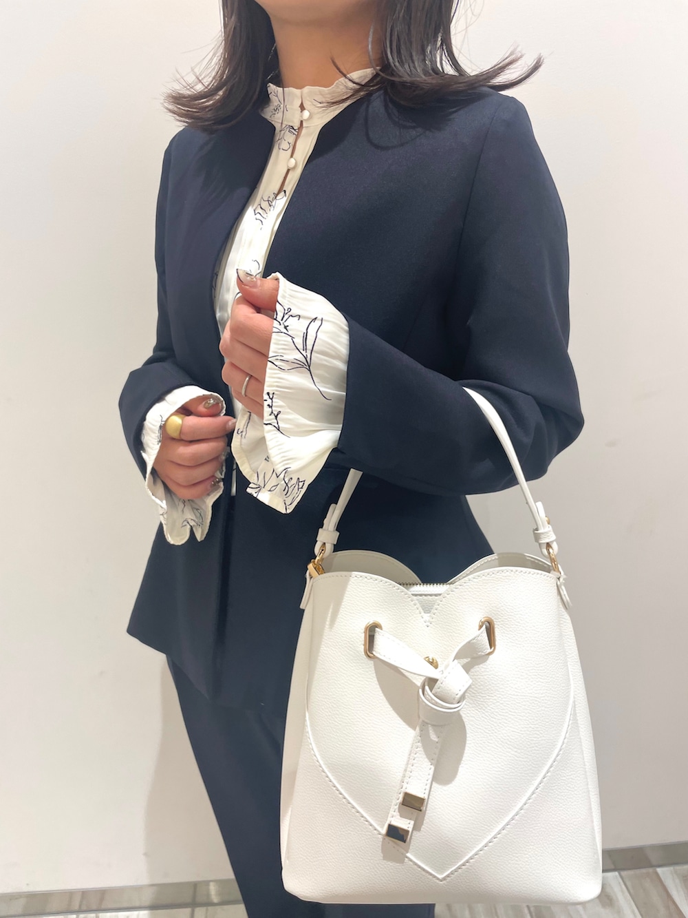 ブルー系のスラックス、ブルー系のノーカラージャケット、ホワイト系のシャツ/ブラウスを着用したレディースの冬コーディネートの2枚目の写真