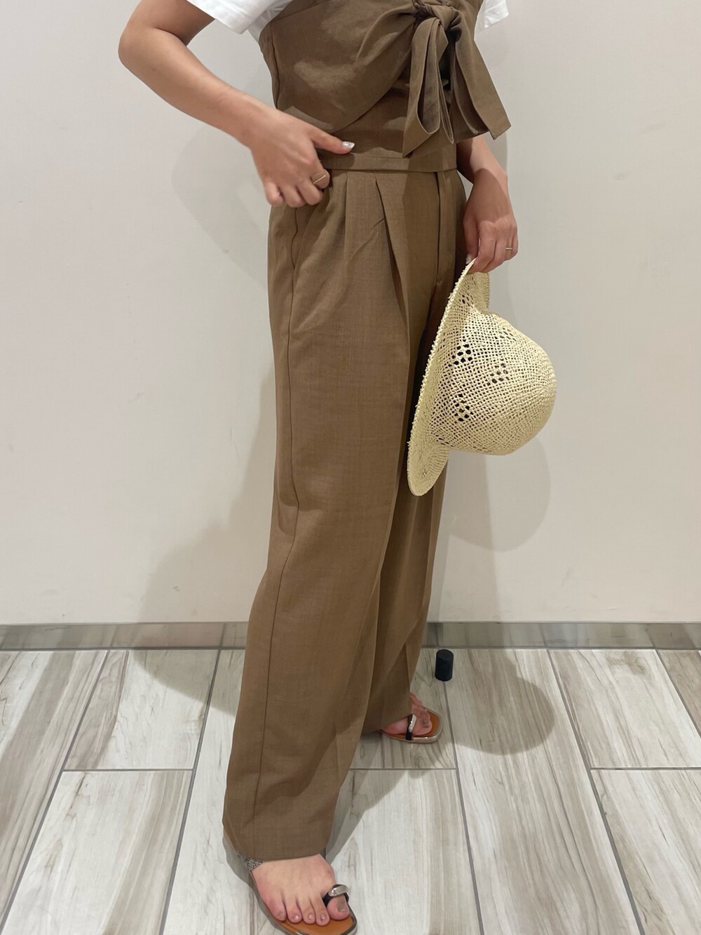 ブラウン系のスラックスを着用したレディースの夏コーディネートの5枚目の写真