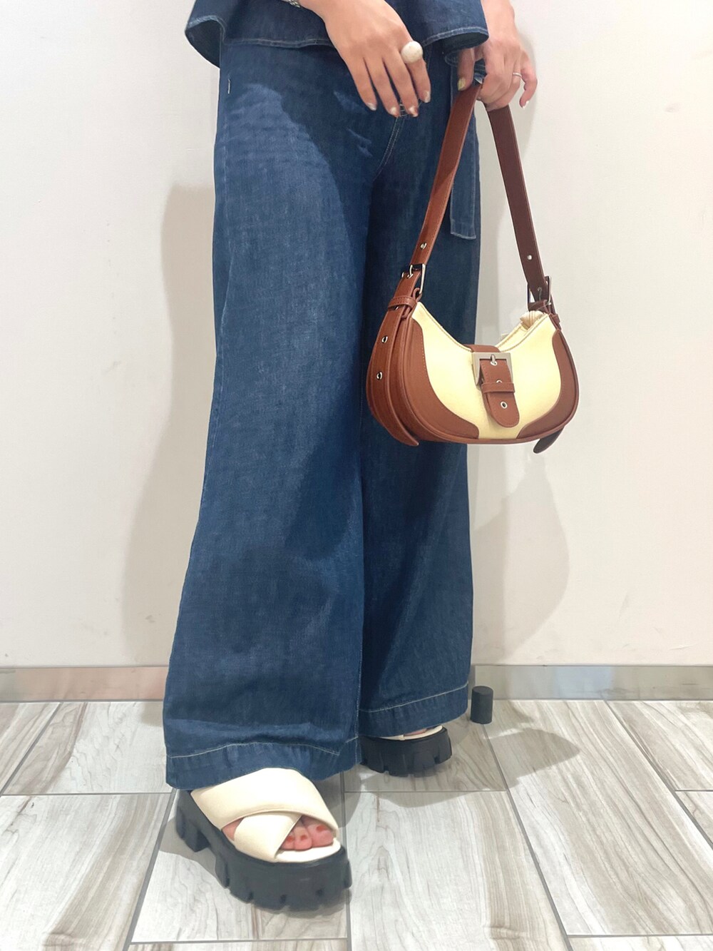 ブルー系のシャツ/ブラウス、ブルー系のデニムパンツ、ブラウン系のショルダーバッグを着用したレディースの春コーディネートの4枚目の写真