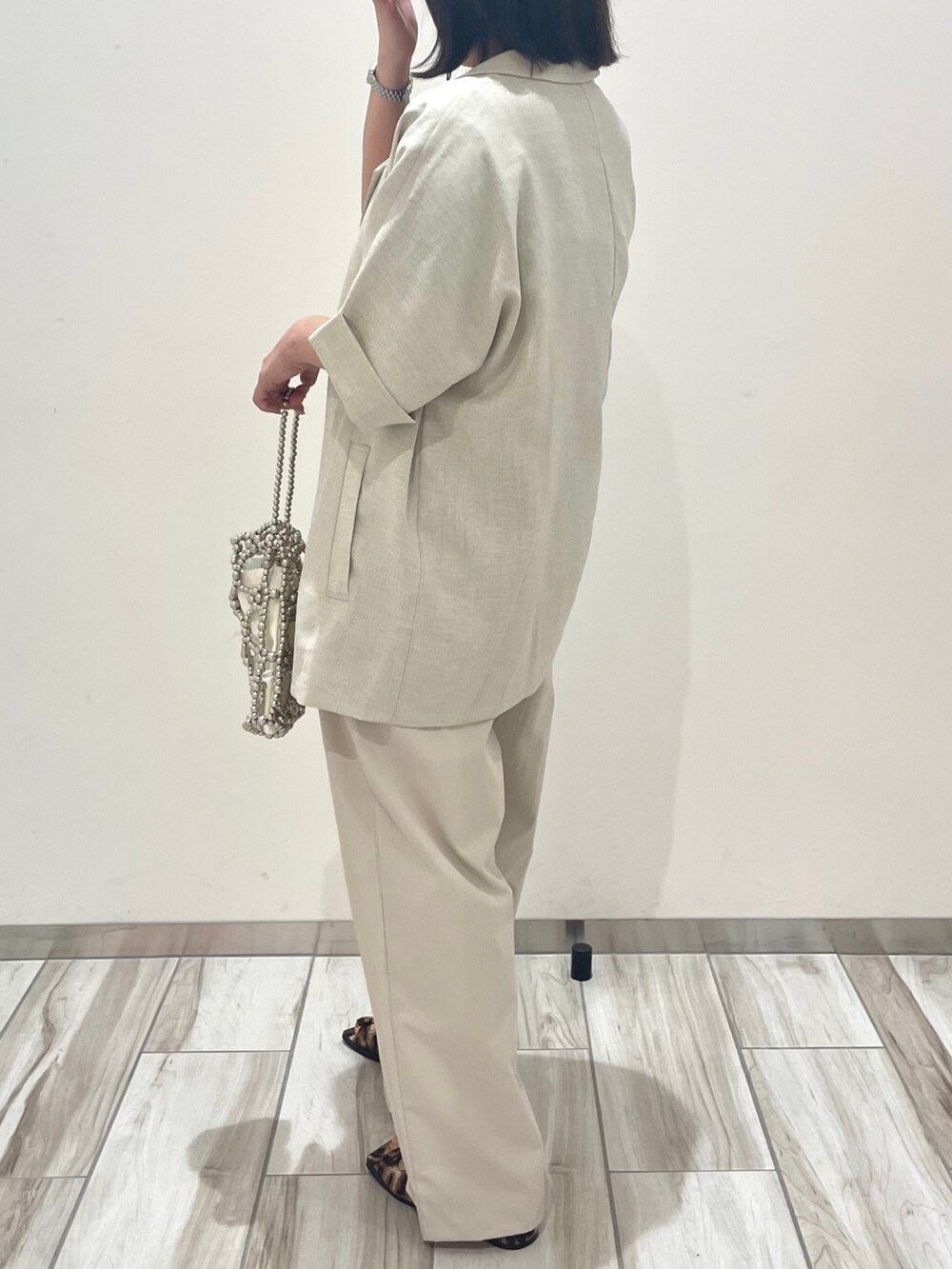 ホワイト系のテーラードジャケット、ベージュ系のその他パンツ、シルバー系のハンドバッグを着用したレディースの春コーディネートの4枚目の写真