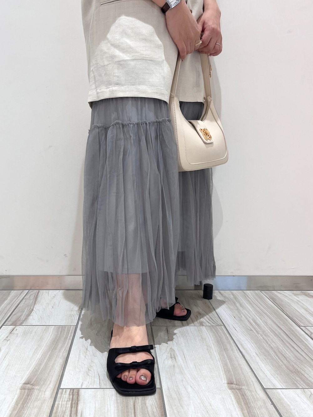 ホワイト系のハンドバッグ、ホワイト系のテーラードジャケット、ホワイト系のニット/セーターを着用したレディースの夏コーディネートの4枚目の写真