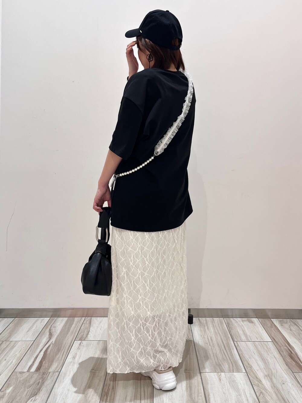 ブラック系のTシャツ/カットソー、ホワイト系のワンピースを着用したレディースの春コーディネートの4枚目の写真