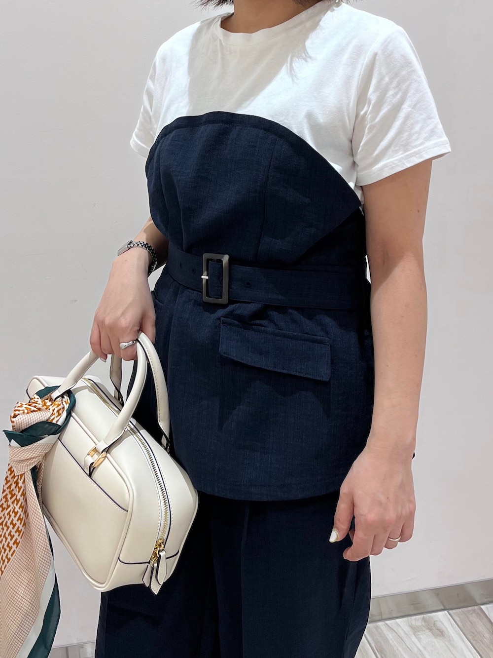 ブルー系のTシャツ/カットソー、ブルー系のスラックス、ホワイト系のボストンバッグを着用したレディースの春コーディネートの3枚目の写真