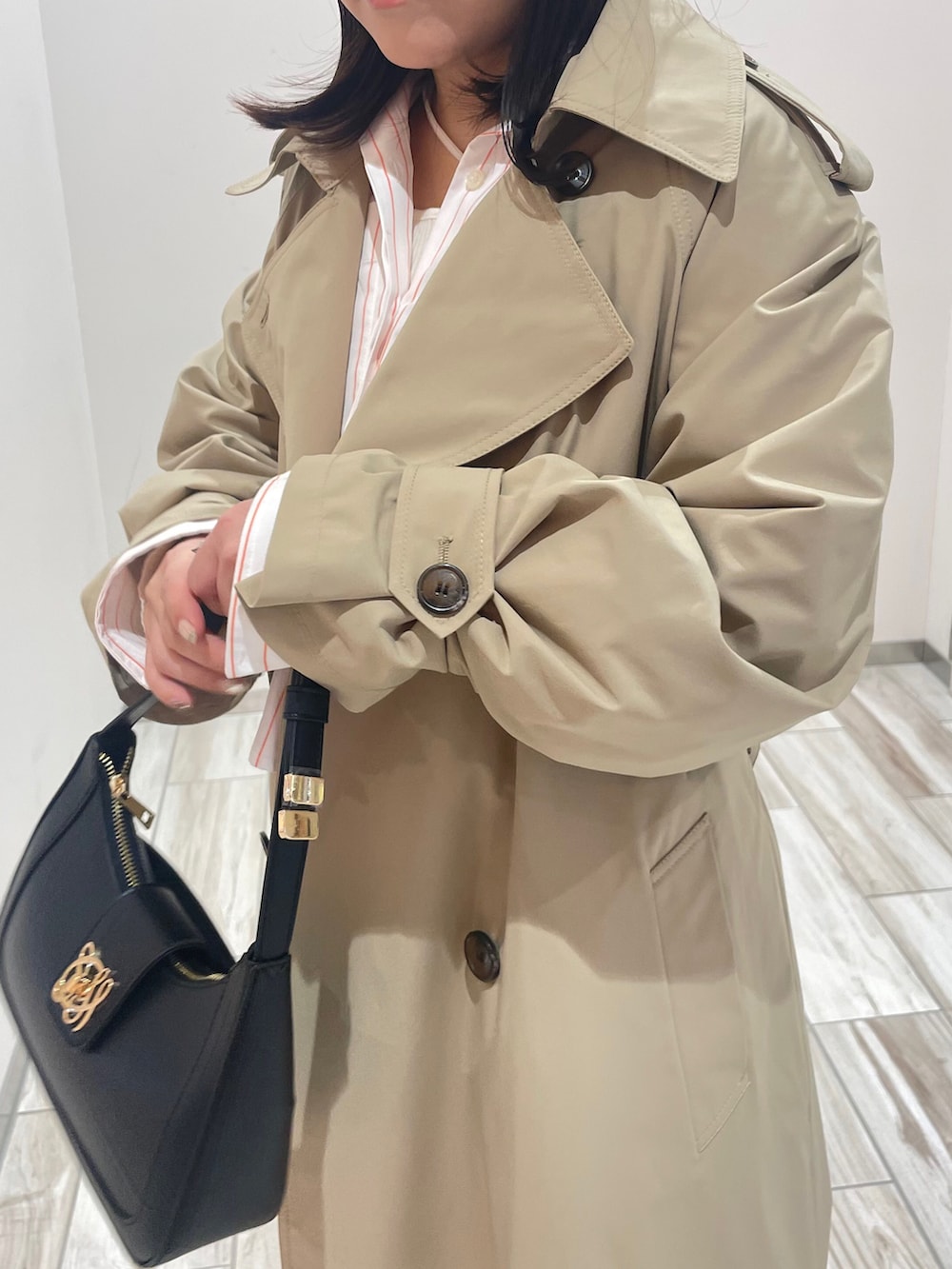 ブラック系のハンドバッグを着用したレディースの冬コーディネートの2枚目の写真