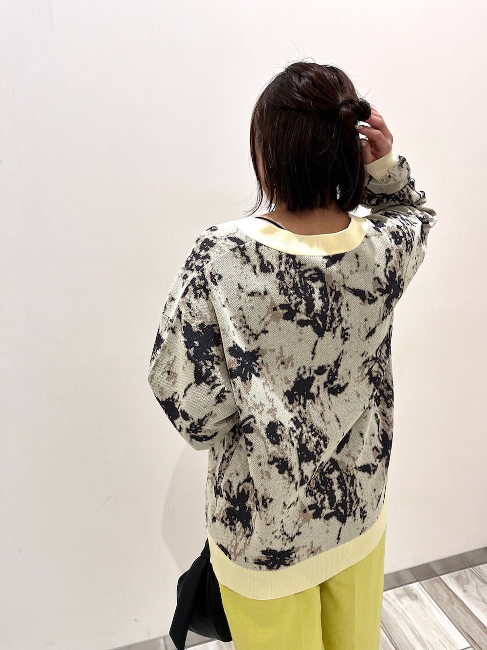 ベージュ系のカーディガン/ボレロ、イエロー系のスラックス、ブラック系のハンドバッグを着用したレディースの春コーディネートの3枚目の写真