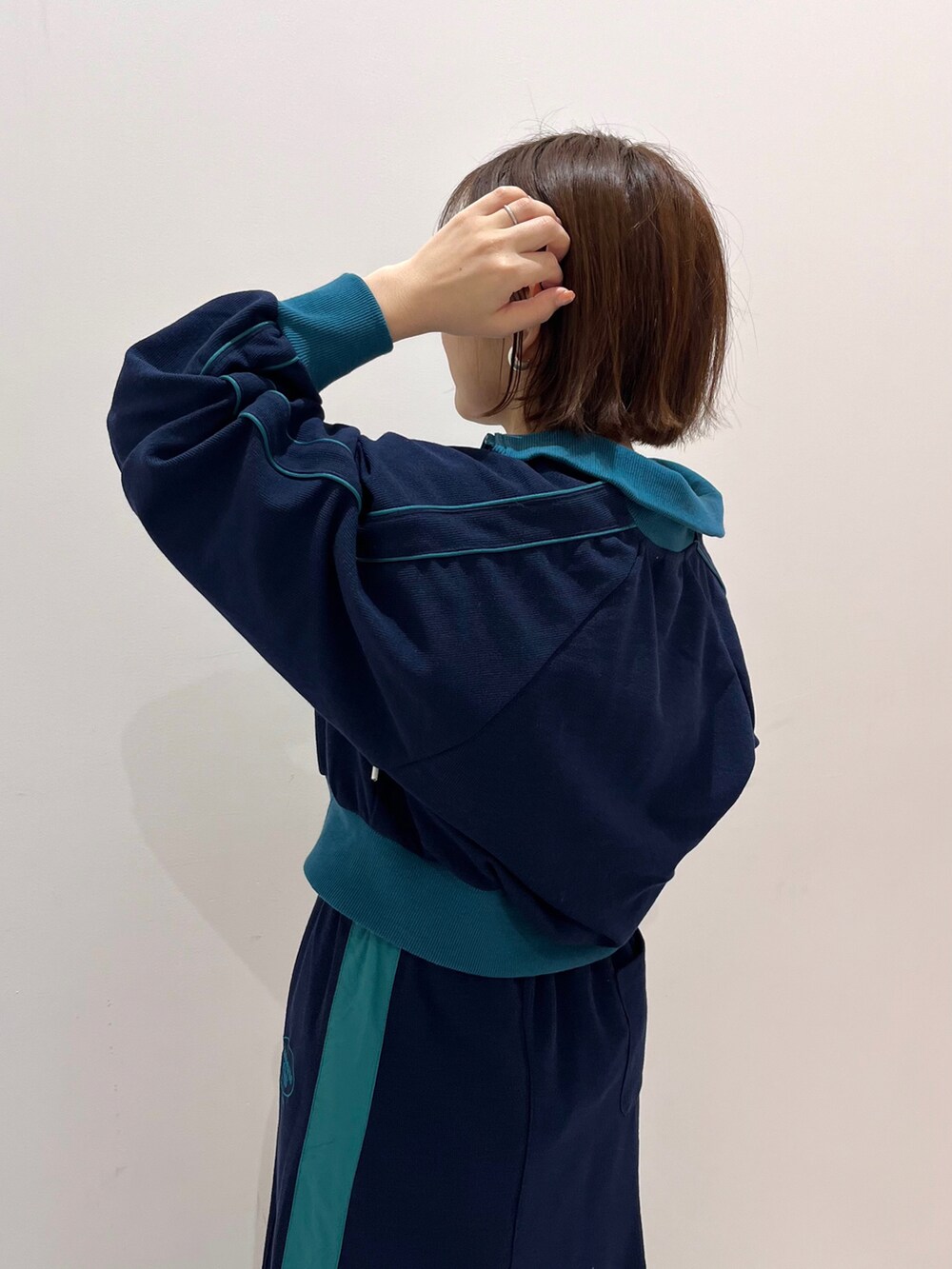 ブルー系のブルゾン、ブルー系のスカート、ホワイト系のハンドバッグを着用したレディースの冬コーディネートの2枚目の写真