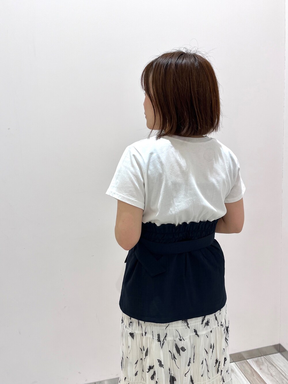 ブルー系のデニムジャケット、ブルー系のTシャツ/カットソー、ホワイト系のスカートを着用したレディースの春コーディネートの5枚目の写真