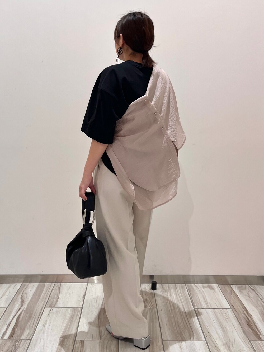 ブラック系のTシャツ/カットソー、ピンク系のシャツ/ブラウス、ホワイト系のスラックスを着用したレディースの春コーディネートの5枚目の写真