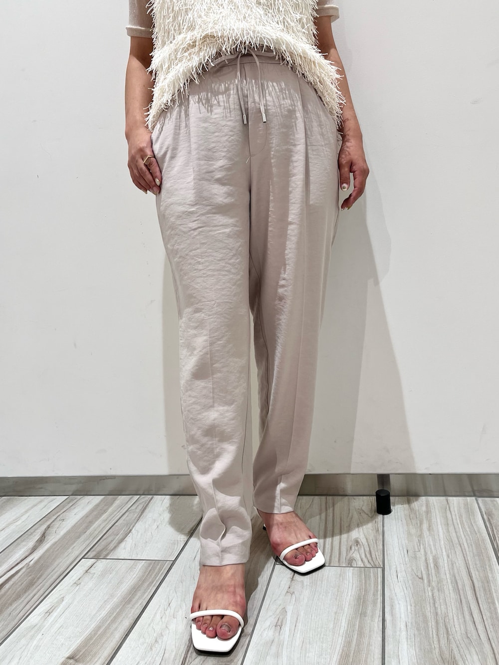 ホワイト系のタンクトップ、ホワイト系のTシャツ/カットソー、ホワイト系のスラックスを着用したレディースの夏コーディネートの4枚目の写真