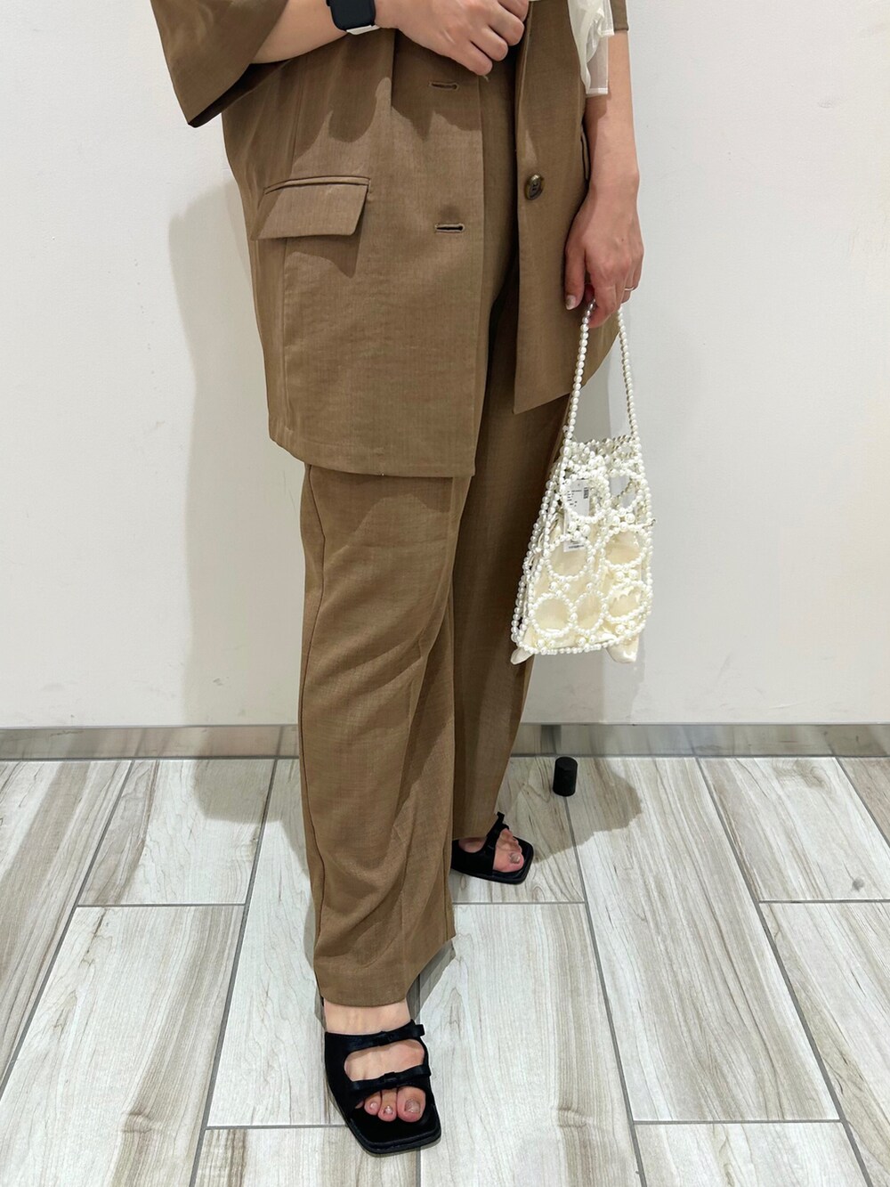 ホワイト系のTシャツ/カットソー、ブラウン系のテーラードジャケット、ブラウン系のスラックスを着用したレディースの夏コーディネートの4枚目の写真