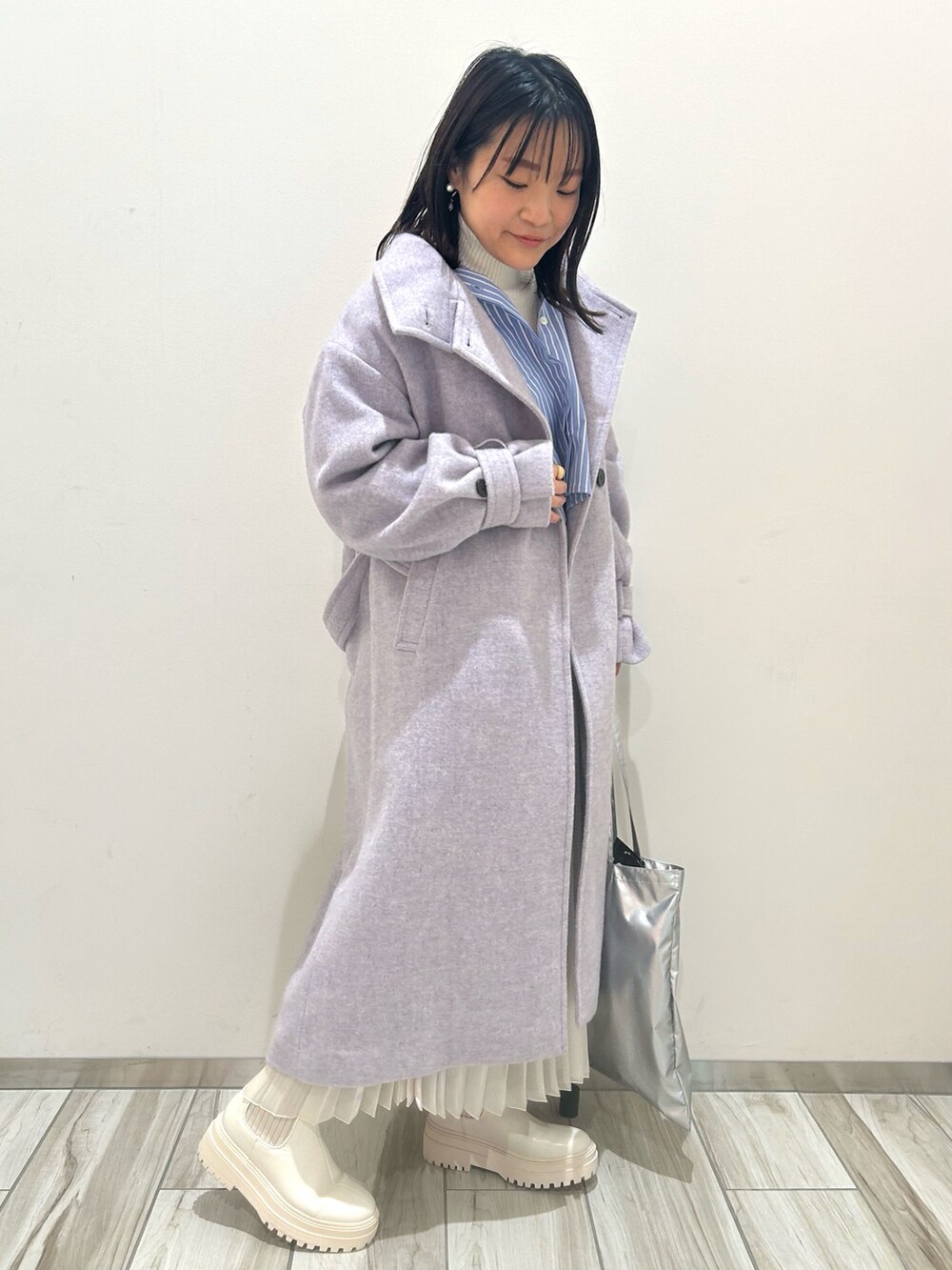 シルバー系のトートバッグ、パープル系のその他アウター、ブルー系のシャツ/ブラウスを着用したレディースの冬コーディネートの2枚目の写真