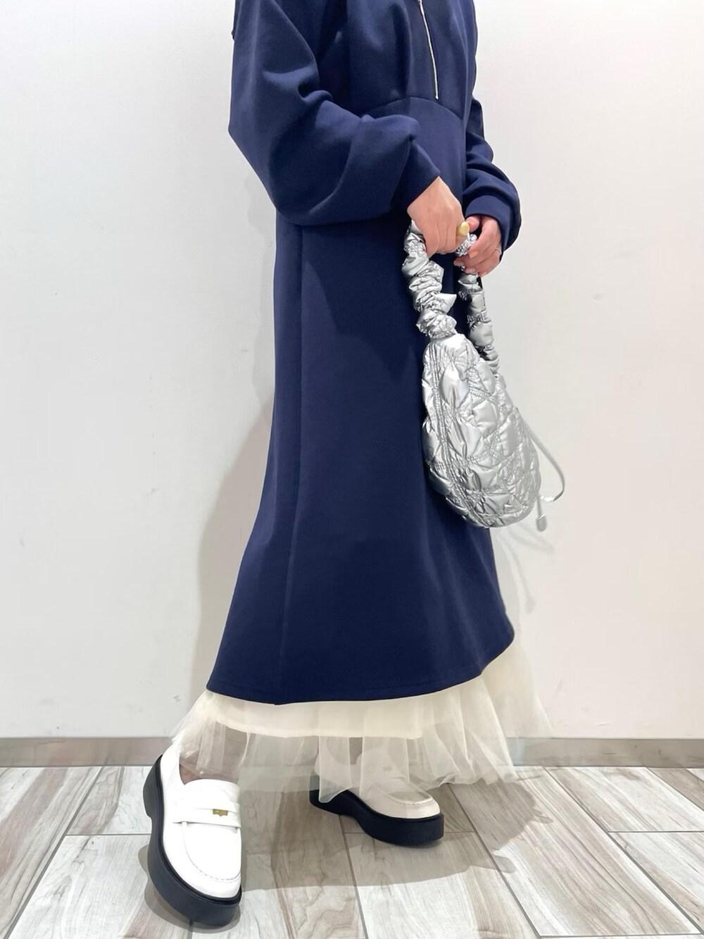 ブルー系のワンピース、ホワイト系のスカート、シルバー系のショルダーバッグを着用したレディースの冬コーディネートの3枚目の写真