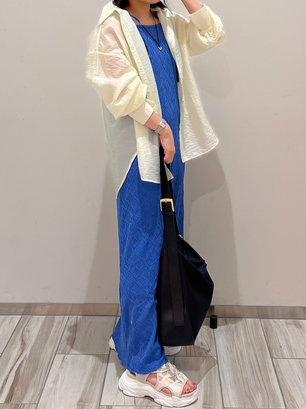 ブルー系のワンピース、ホワイト系のシャツ/ブラウスを着用したレディースの春コーディネートの2枚目の写真