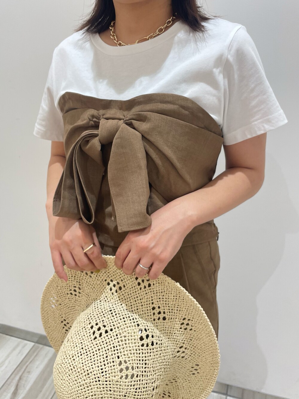 ブラウン系のスラックスを着用したレディースの夏コーディネートの3枚目の写真