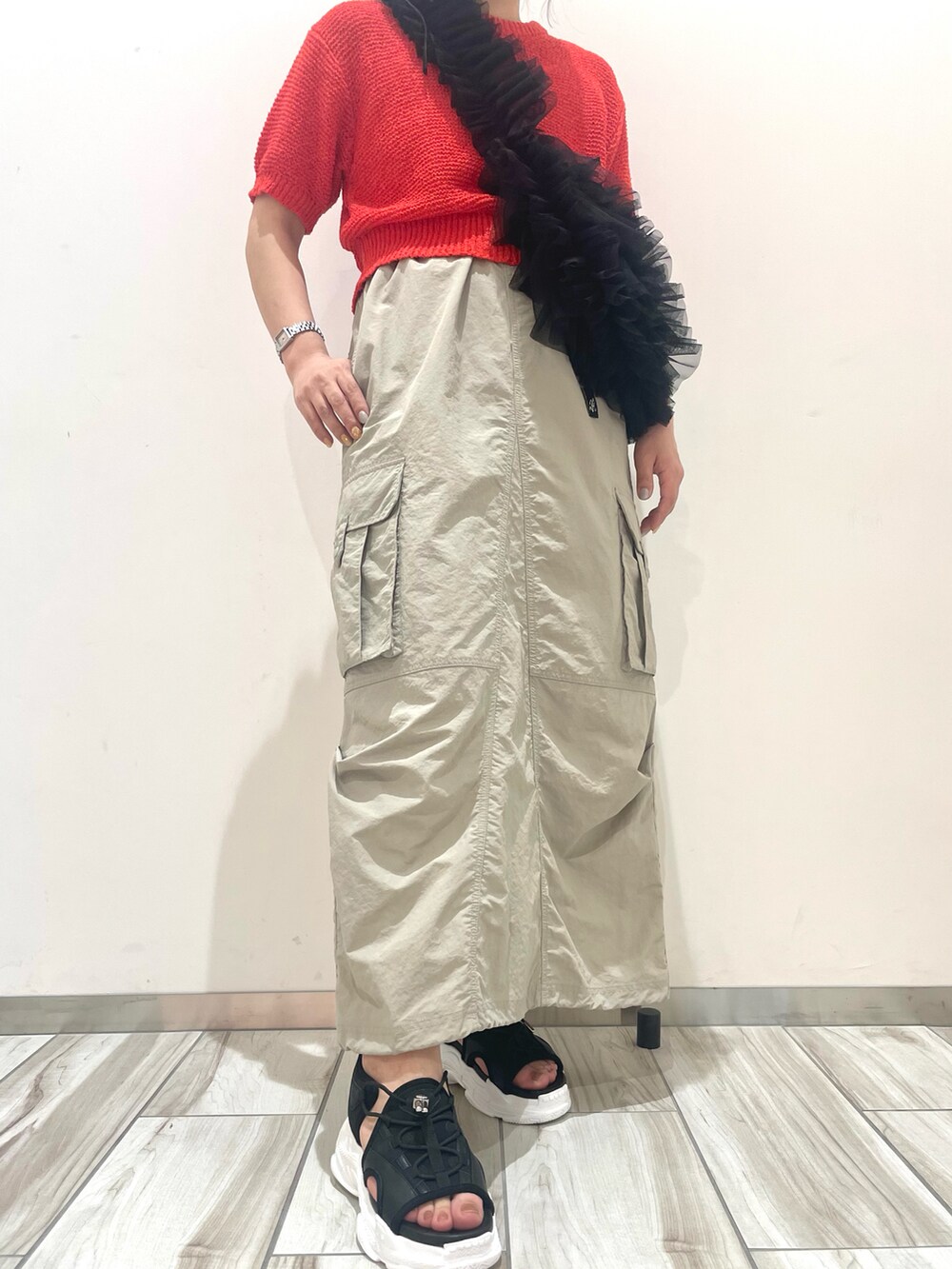 レッド系のニット/セーター、ブラック系のショルダーバッグを着用したレディースの春コーディネートの3枚目の写真