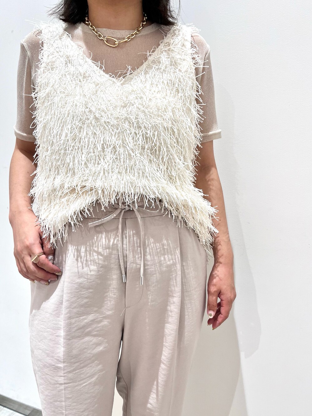 ホワイト系のタンクトップ、ホワイト系のTシャツ/カットソー、ホワイト系のスラックスを着用したレディースの夏コーディネートの3枚目の写真